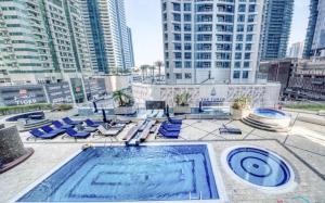 a swimming pool with blue lounge chairs and buildings at Life Above Clouds in Dubai