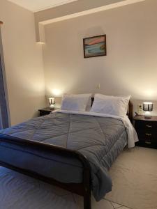 a bed in a bedroom with two night stands and two lamps at Αρτέμιδα Karpenisi Apartment in Karpenisi