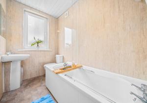 a bathroom with a tub and a sink at Anderson Apartment by Klass Living Motherwell in Motherwell