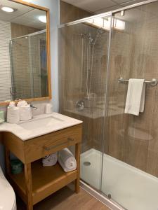 uma casa de banho com um lavatório e um chuveiro em The Lodge Luxury Resort At Lake Harmony em Lake Harmony