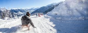 Eine Person fährt einen schneebedeckten Berg hinunter in der Unterkunft Brixnerhof im Zillertal in Schlitters