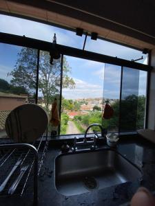 a kitchen with a sink and a window with a view at Casa Buena Vibra Hostel in São João del Rei