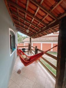 a red hammock hanging from a roof in a house at Casa Buena Vibra Hostel in São João del Rei