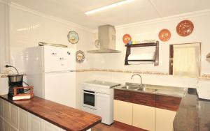 uma cozinha com um frigorífico branco e um lavatório em Cas Conill em Llucmajor
