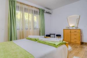 a bedroom with a bed with a dresser and a mirror at Pavle's Oasis in Virpazar