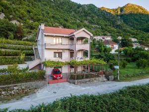 a house with a red car parked in front of it at Pavle's Oasis in Virpazar