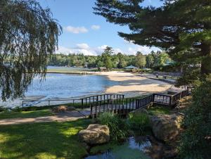 dos bancos en una playa junto a un cuerpo de agua en The Lodge Luxury Resort At Lake Harmony, en Lake Harmony