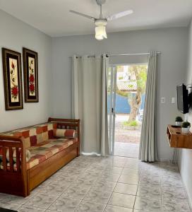 ein Wohnzimmer mit einem Sofa und einer Glasschiebetür in der Unterkunft Férias de Verão - Bombinhas in Bombinhas