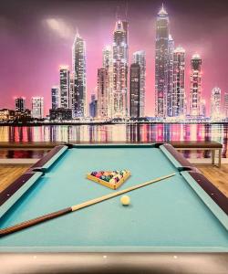 a pool table with a city skyline in the background at Life Above Clouds in Dubai
