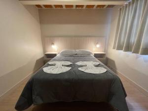 Canela的住宿－Loft 9 entre gramado e canela，一间卧室配有一张床,上面有两条毛巾