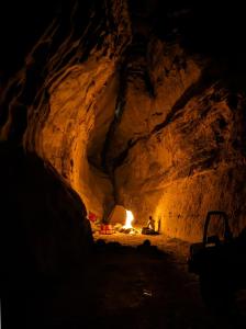 a person sitting in a cave with a fire in it at Wadi rum view camp in Wadi Rum