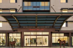 un bâtiment avec deux statues de chevaux devant lui dans l'établissement Hampton Inn & Suites San Mateo-San Francisco Airport, à San Mateo