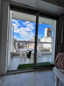 balcón con mesa y vistas a la ciudad en Estudio en Barrio Martin Rosario en Rosario