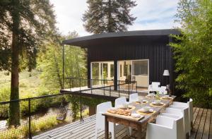 une maison avec une table et des chaises blanches sur une terrasse dans l'établissement Villa Combade, à Masléon