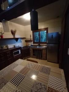 a kitchen with a black refrigerator and a table at Casa com vista para o vale - Serra Gaúcha in Nova Petrópolis
