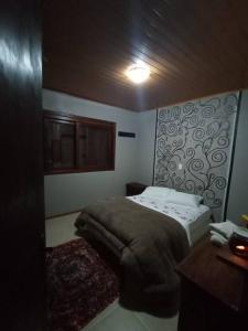 um pequeno quarto com uma cama e uma secretária em Casa com vista para o vale - Serra Gaúcha em Nova Petrópolis