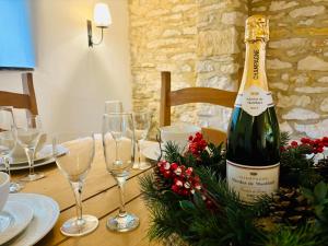 a bottle of wine sitting on a table with glasses at Cotswold Home over 4 floors - perfect for Families Friends Contractors in Chipping Norton