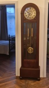 a grandfather clock sitting in the corner of a room at Historisches Badehaus in Hoym