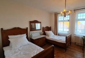 a bedroom with two beds and a mirror at Historisches Badehaus in Hoym