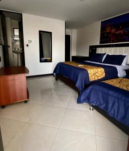 a bedroom with two beds and a dresser at Hotel Casa Modelia in Bogotá