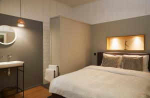 a bedroom with a bed and a sink and a mirror at Villa Combade in Masléon