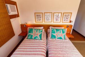 2 nebeneinander sitzende Betten in einem Schlafzimmer in der Unterkunft Paraíso Pé na Areia de Geribá com Cinco Suítes Por Luxury Rentals in Búzios