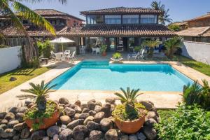 ein Pool vor einem Haus in der Unterkunft Paraíso Pé na Areia de Geribá com Cinco Suítes Por Luxury Rentals in Búzios