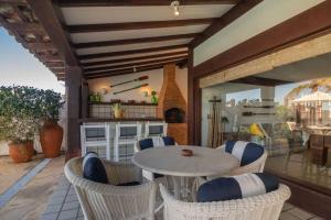 a patio with a table and chairs on a porch at Paraíso Pé na Areia de Geribá com Cinco Suítes Por Luxury Rentals in Búzios