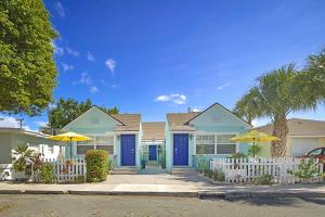 una fila de casas con puertas azules y una valla blanca en Steps to Beach & Downtown! Cozy Beach Bungalow #1, en Lake Worth