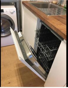 an open dishwasher with its rack inside of it at Studio Confort centre ville in Bordeaux