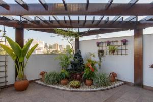 une terrasse avec un bouquet de plantes et de plantes en pot dans l'établissement Faro Hotel São José dos Campos, à São José dos Campos