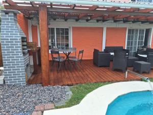 - une terrasse en bois avec une table et des chaises à côté de la piscine dans l'établissement Altos de Kiyu, à José Ignacio
