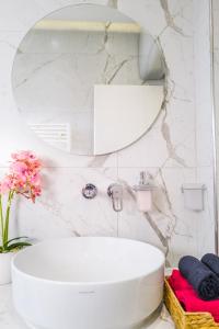 uma casa de banho com um lavatório branco e um espelho. em The Actors Studio em Tirana
