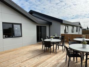 una terraza con mesas y sillas en una casa en Höfn Hostel, en Höfn