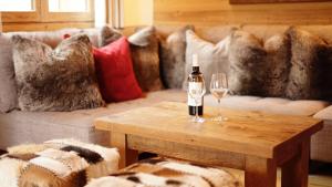 uma sala de estar com uma garrafa de vinho e copos numa mesa em Chalet Mimi em Morzine