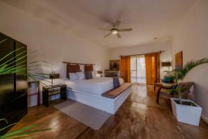 a bedroom with a bed and a couch and a fan at La Poza Boutique Hotel and Spa - Adults 15 plus in Todos Santos