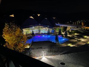 un grande edificio con luci blu di notte di Apartma AS a Podcetrtek