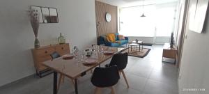 einen Esstisch und Stühle im Wohnzimmer in der Unterkunft Le Local in Koenigsmacker