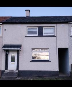 a gray house with a white door and a window at Stunning 3 bedroom FMHomes & Apartments in Uddingston