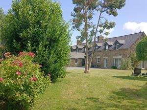 a house with a yard with flowers and bushes at Relais de Moidrey in Moidrey