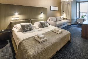 a hotel room with a bed with towels on it at Hotel Logos Kraków in Krakow