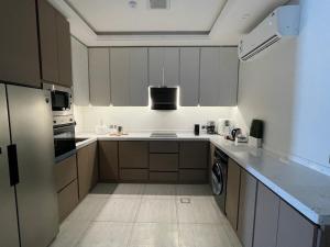 a kitchen with white cabinets and a stove top oven at A luxury three-bedroom apartment in the heart of Riyadh in Riyadh