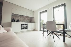 uma sala de estar branca com um sofá e uma mesa em Lenneapartments Premium em Plettenberg