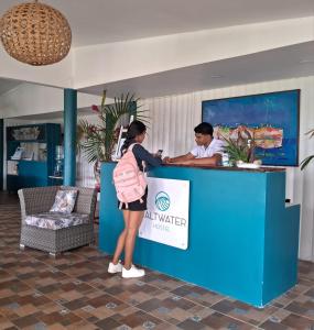 a woman standing at a counter with a man at Hostel SaltWater in San Juan del Sur