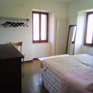 een slaapkamer met een bed, een bureau en ramen bij Casa del Gigi BnB in Albareto