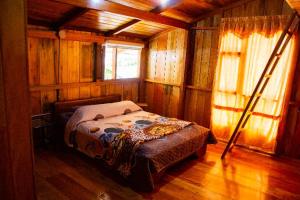 1 dormitorio con 1 cama en una habitación con paredes de madera en RANA DE CRISTAL en Mindo