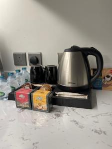 a black and silver tea pot sitting on top of a microwave at A luxury three-bedroom apartment in the heart of Riyadh in Riyadh