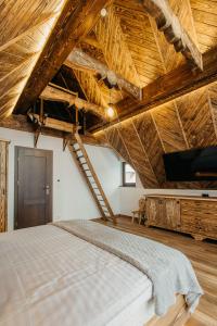a large bedroom with a large bed and a tv at Domek na Wilczniku in Zakopane