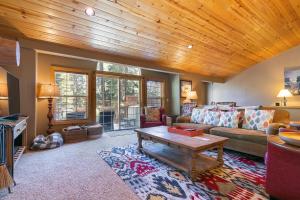 un soggiorno con un divano e un tavolo di Alpen Glow by Tahoe Getaways - Private Hot Tub, Close to Northstar a Carnelian Bay