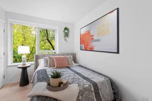 a bedroom with a bed and a large window at Elegant 2-Bedroom Duplex Haven in Vibrant Yaletown in Vancouver